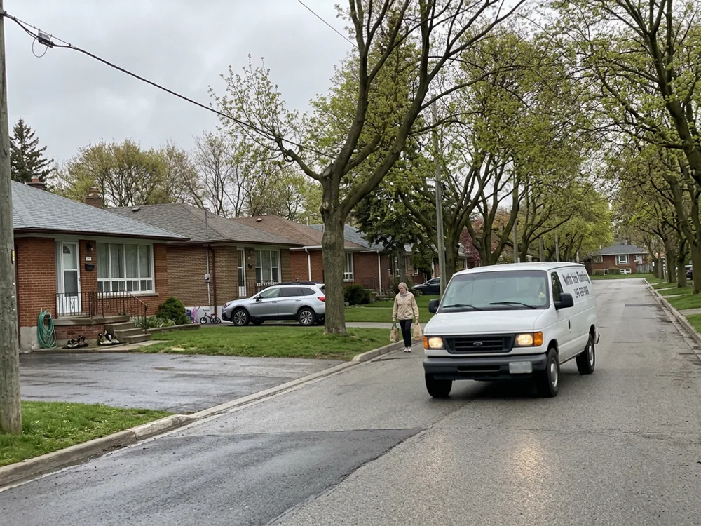 Service van on a tree-lined North York street of 1960s bungalows